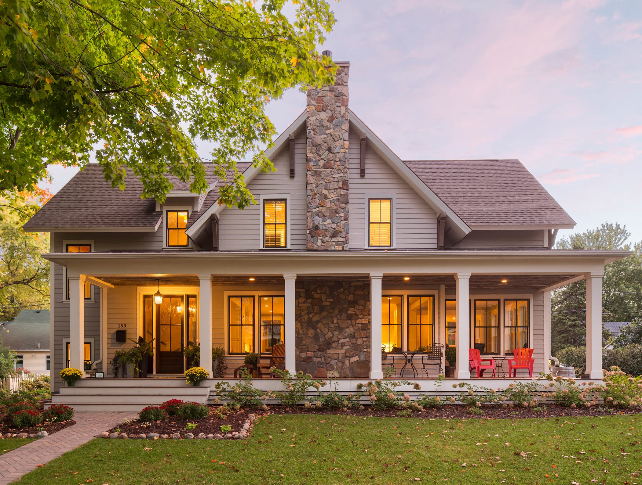 Stone Tennessee farmhouse at dusk with a warmly lit porch